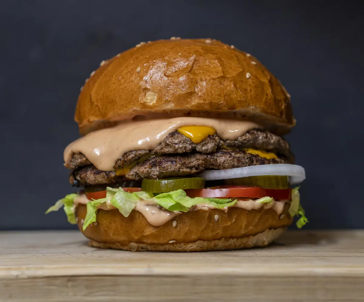 A delicious gourmet burger with fresh ingredients on a wooden board
